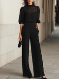 Conjunto de tres piezas en negro, compuesto por un top camisola transparente y unos pantalones de pierna ancha