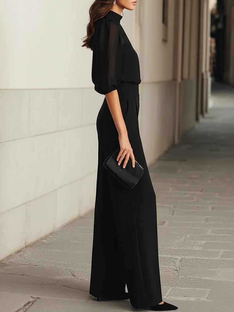Conjunto de tres piezas en negro, compuesto por un top camisola transparente y unos pantalones de pierna ancha